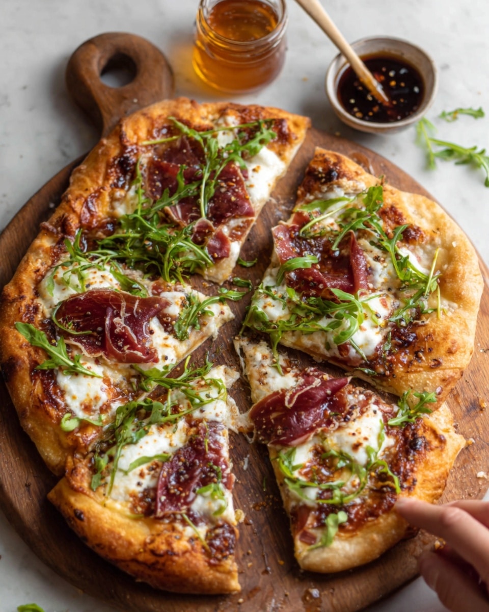 A rustic pizza with four slices, each topped with thin, folded dark red cured meat, melted creamy white cheese with some golden brown spots, and fresh green arugula leaves scattered on top. The crust is golden brown with a slightly thick, bubbly texture. The pizza is on a brown wooden board with a small bowl of dark sauce and a glass jar of honey in the background, all placed on a white marbled surface. A woman's hand is reaching out toward the pizza. photo taken with an iphone --ar 4:5 --v 7
