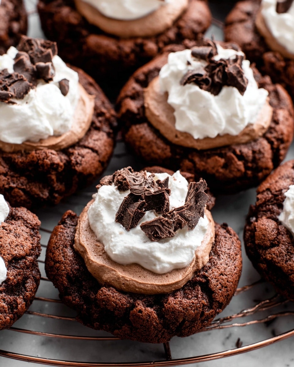 The image shows several rich, dark brown chocolate cookies with a rough, crunchy texture, placed close together on a round wire cooling rack over a white marbled surface. Each cookie has two distinct creamy layers on top: the bottom layer is smooth and light brown, resembling chocolate mousse, and the top layer is soft white whipped cream arranged unevenly on one side. Dark chocolate curls are scattered over the white cream, adding detail and contrast to the topping. The overall look is dense and indulgent, with the fluffy toppings softening the cookies' rugged appearance. photo taken with an iphone --ar 4:5 --v 7