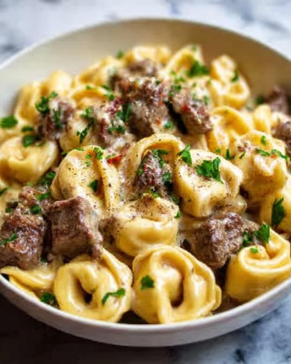 A close-up of a white bowl filled with tortellini pasta covered in a creamy sauce. The tortellini are golden yellow with small folds and rounded shapes. On top of the pasta, there are chunks of brown cooked meat scattered evenly. Fresh green parsley leaves are sprinkled over the dish, adding a pop of color. The sauce looks smooth and light, coating the pasta and meat well. The bowl is placed on a white marbled surface. Photo taken with an iphone --ar 4:5 --v 7