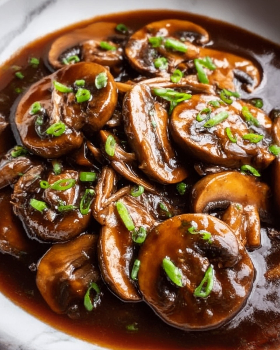 The image shows a close-up of cooked brown mushrooms with a shiny, thick sauce coating them. The mushrooms are cut into slices and arranged showing their smooth texture and a glossy, dark brown color, topped with small pieces of green onion scattered evenly on the surface. They sit on a white plate with a white marbled texture underneath. The rich sauce pools slightly around the mushrooms, adding a wet, glossy look. photo taken with an iphone --ar 4:5 --v 7